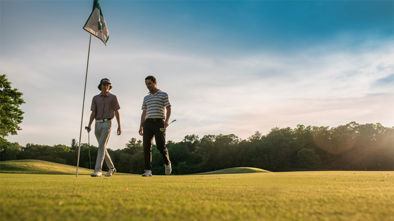 Two gentlemen walking through Trappers Turn Golf Course.